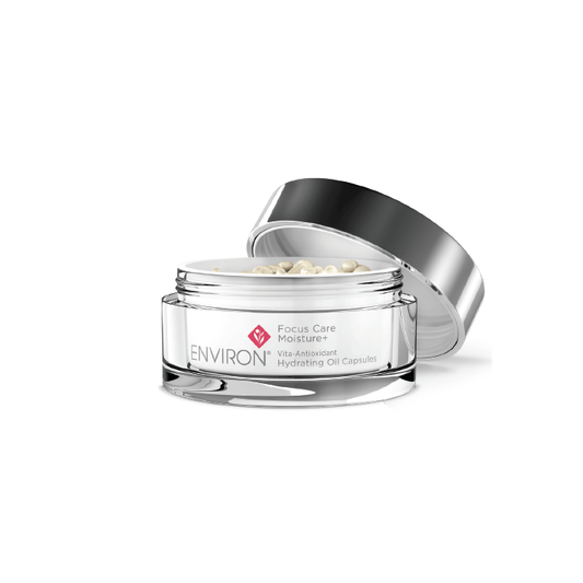 A clear jar labeled Vita-Antioxidant Hydrating Oil Capsules with a silver lid rests open, showing small, pearl-like capsules filled with antioxidants inside.