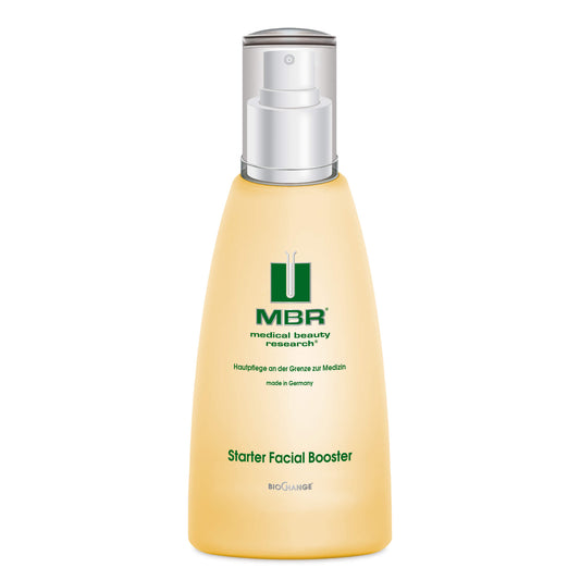 A yellow bottle of Starter Facial Booster with a silver and white pump dispenser, labeled “medical beauty research” and “made in Germany,” ideal for skin stimulation and reducing fine lines.