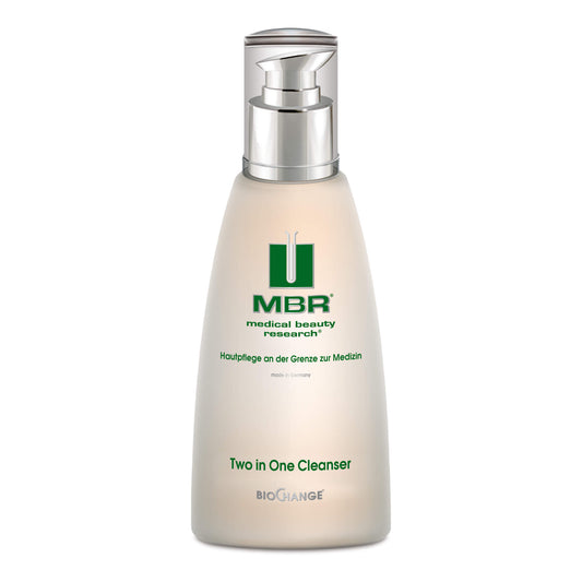 A white pump bottle labeled Two in One Cleanser stands upright on a white background, featuring green and silver accents, German text, and skin-friendly emulsifiers plus amino acids.
