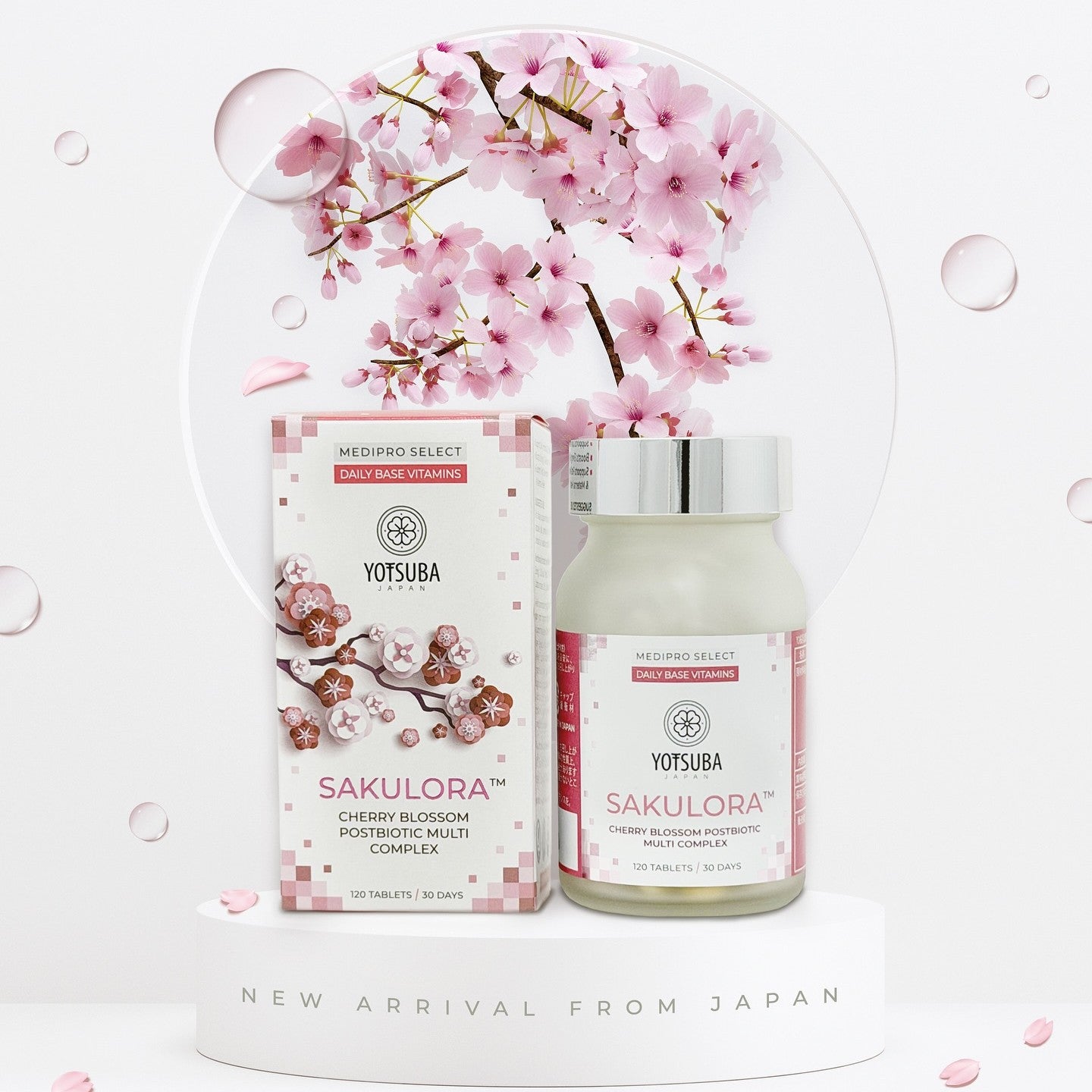 A box and bottle of Cherry Blossom Postbiotic Multi Complex are displayed before a cherry blossom branch, petals scattered around. Text at the bottom reads New Arrival from Japan.