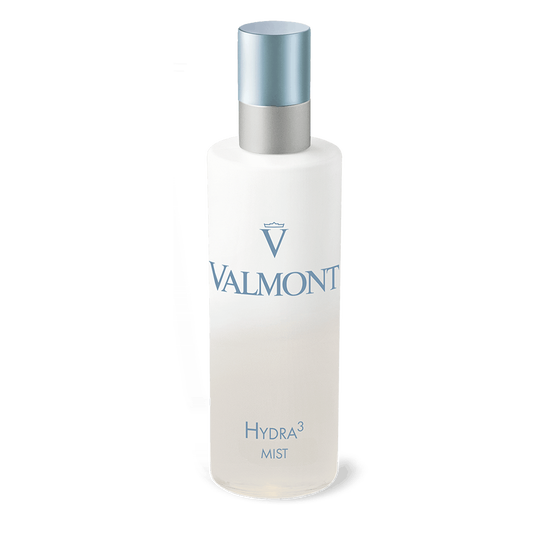 A frosted bottle of Hydra3 Mist with a silver and blue cap, featuring the Valmont logo and product name in light blue text on white—a luxurious hydrating mist for face and body.