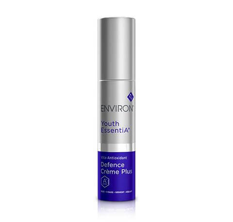 A silver and blue cylindrical bottle labeled Antioxidant Defence Crème Plus, featuring antioxidants and Retinyl Palmitate, stands on a white background.